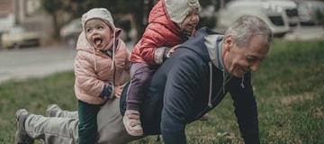 Grandpa with grandchildren climbing on his back